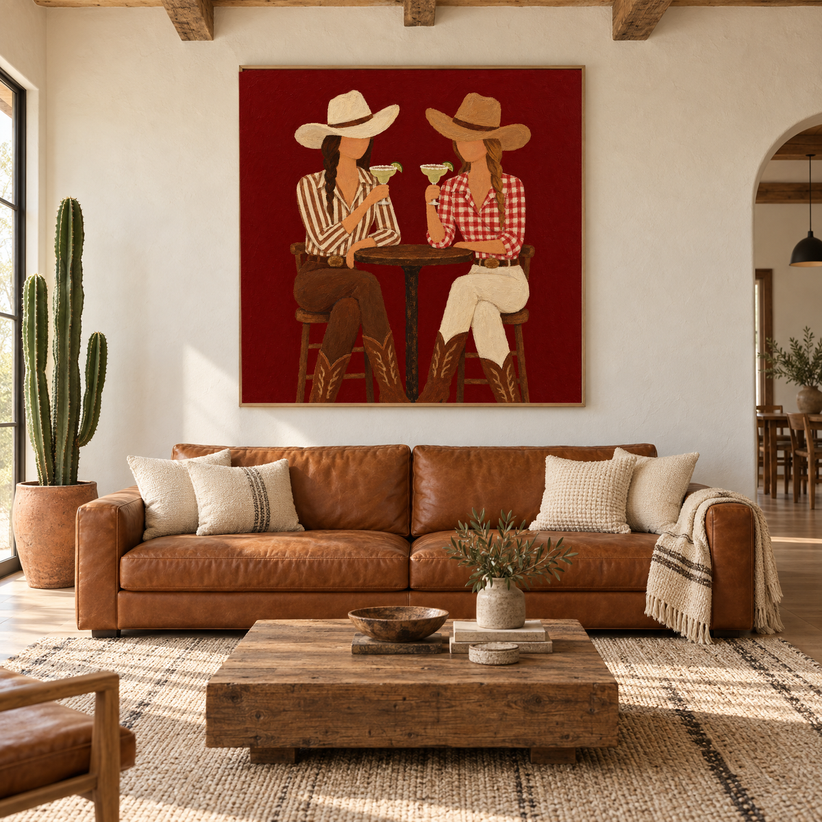 Oversized 72x72 inch western folk art oil painting of two cowgirls toasting margaritas above a sofa in a modern ranch-style living room