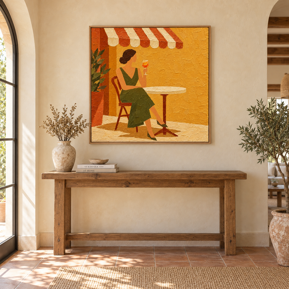 40x40 inch cafe terrace oil painting of a woman with an orange spritz above a console table in a sunlit Mediterranean villa entryway