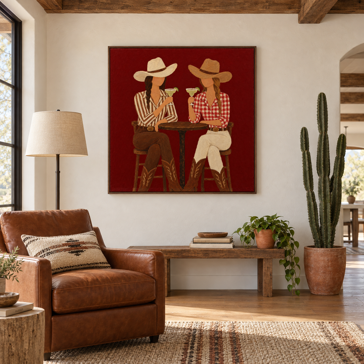 40x40 inch western folk art oil painting of two cowgirls toasting margaritas in a walnut frame in a modern ranch-style reading corner